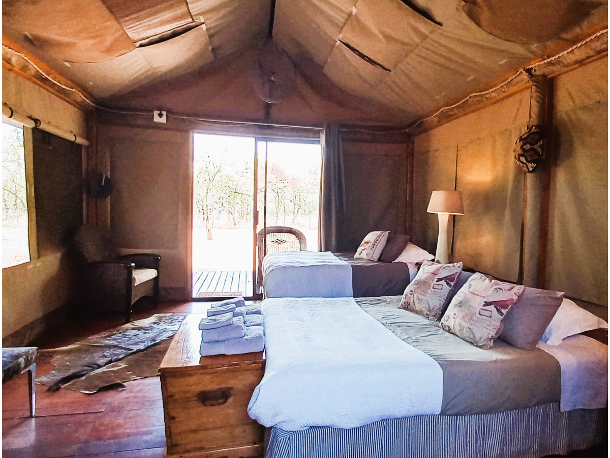 Bedroom Luxury Safari Tents Luxury Safari Tent colonial-style interior with queen and single bed with outside view